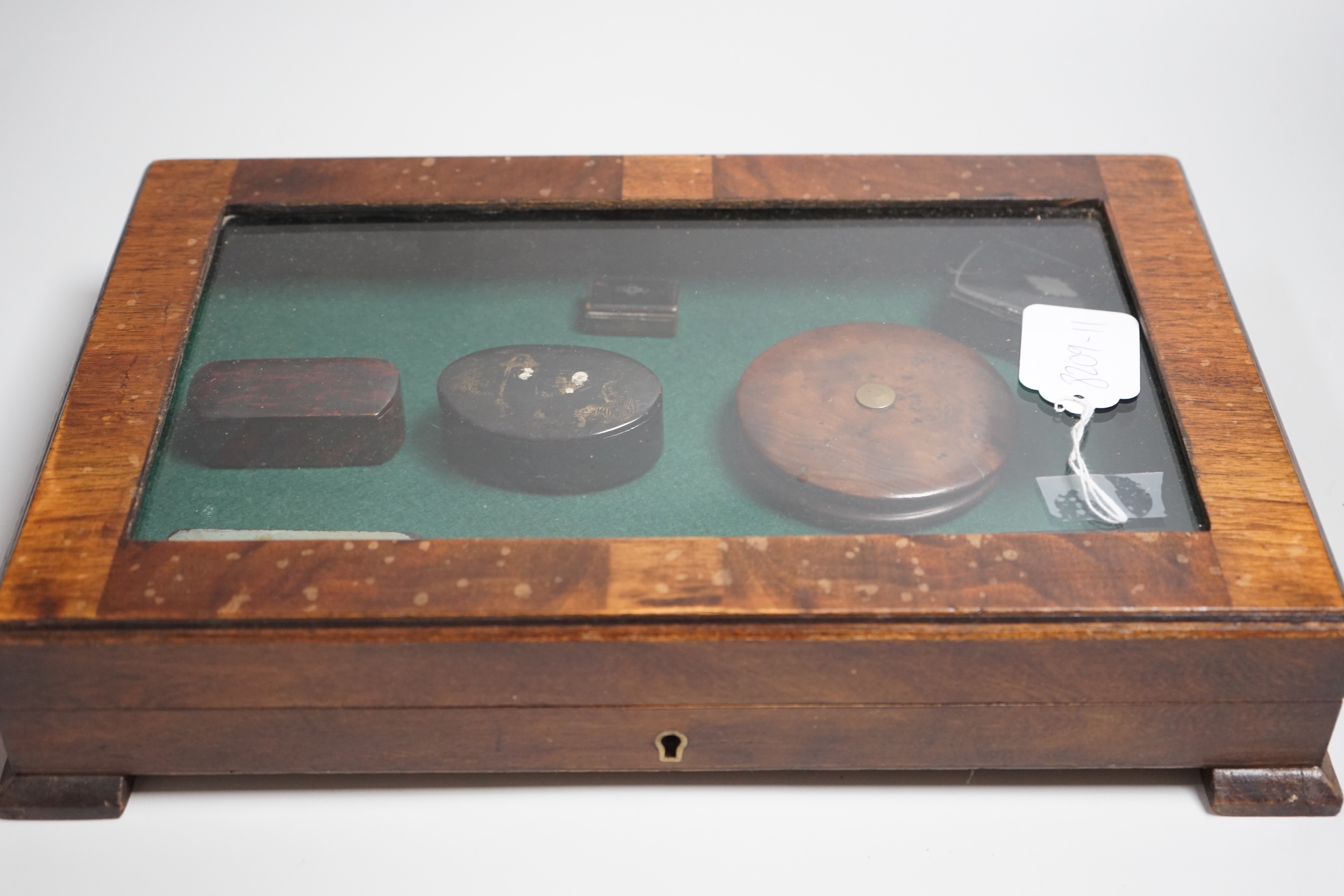 A collection of turned treen and various japanned papier mache boxes, contained in a glazed topped mahogany box-37cms x 24cms